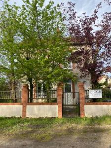 um edifício de tijolos com um portão e um sinal nele em Maison les 3 fées , 3 chambres, Chamerolles em Courcy-aux-Loges