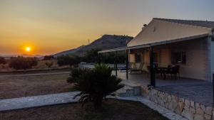 a house with the sunset in the background at O κήπος της Εδέμ / Garden of Eden in Sagiada