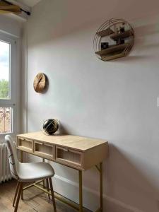 uma secretária num quarto com uma cadeira e uma janela em Maison les 3 fées , 3 chambres, Chamerolles em Courcy-aux-Loges