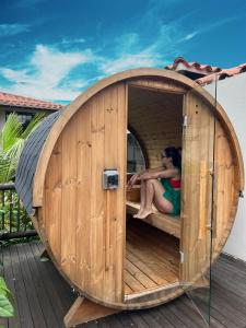 a woman is sitting in a wooden dog house at 1714 Hotel Boutique Guatapé in Guatapé