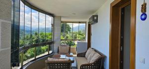 RizeKonak Luxury Villa Private Garden Ac Sea View في ريزي: غرفة مع نافذة كبيرة مع أريكة وكراسي