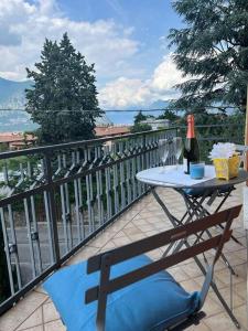- une table avec une bouteille de vin sur le balcon dans l'établissement Terrazza sul lago (CIR 017085-LNI-00027), à Iseo