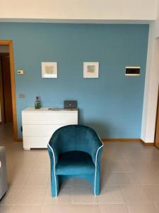 une chaise bleue dans une pièce dotée d'un mur bleu dans l'établissement Terrazza sul lago (CIR 017085-LNI-00027), à Iseo