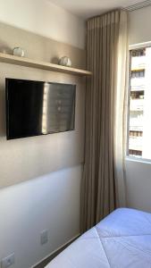 a bedroom with a bed and a television on the wall at Márcia Santos in Curitiba