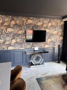 salon ze ścianą z telewizorem i wentylatorem w obiekcie Golden Flamingo Apartment w Gdańsku