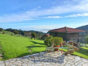 a house on a hill with a green yard at La Tablada in Recuevo