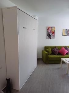 a living room with a green couch and a sliding door at Estudio El Faro II in Torrox Costa