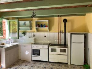 a kitchen with white appliances and a sink at Casa del Castagno: un nido nel castagneto in Pistoia