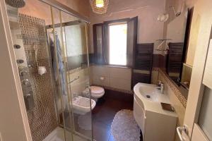 uma casa de banho com um chuveiro, um WC e um lavatório. em Luxury Apartments Campofelice em Campofelice di Roccella