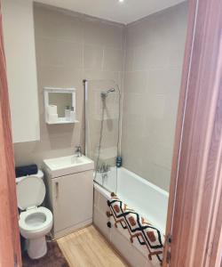 a bathroom with a toilet and a bath tub at Imperial Suites Heart Of Margate! sleeps 6 in Kent