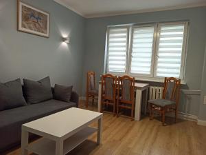 a living room with a couch and a table and chairs at Apartament Arkada Centrum in Rzeszów