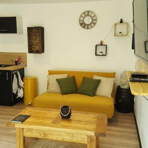 Una sala de estar con un sofá y una mesa de café. en Appartement 2 pieces, en Gravières