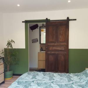 Un dormitorio con una cama y una puerta de madera. en Appartement 2 pieces, en Gravières 10 fotos más