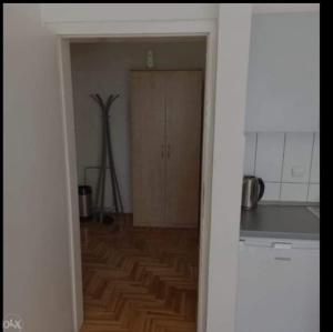 a room with a kitchen with a wooden floor at Apartman (stan na dan) M&M 2 Prijedor in Prijedor