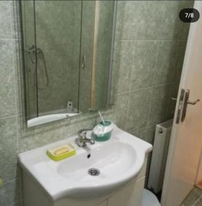 La salle de bains est pourvue d'un lavabo, d'un miroir et de toilettes. dans l'établissement Apartman (stan na dan) M&M 2 Prijedor, à Prijedor