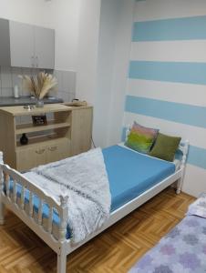 a small bedroom with a bed and a kitchen at Apartman (stan na dan) M&M 2 Prijedor in Prijedor