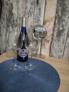 - une bouteille de vin et deux verres sur une table dans l'établissement Apartman (stan na dan) M&M 2 Prijedor, à Prijedor