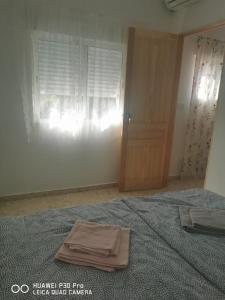 Un dormitorio con una cama con una toalla. en Cassa Beata en La colina, en Cullera