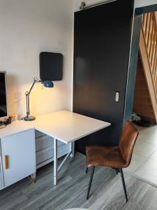 ein Büro mit einem Schreibtisch und einem Stuhl in der Unterkunft Comfortable house 20 min to Paris with garden and BBQ in Épinay-sur-Orge
