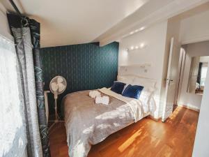 ein Schlafzimmer mit einem großen Bett und einer blauen Wand in der Unterkunft Comfortable house 20 min to Paris with garden and BBQ in Épinay-sur-Orge