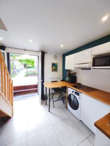 eine Küche mit einer Waschmaschine und einem Schreibtisch in der Unterkunft Comfortable house 20 min to Paris with garden and BBQ in Épinay-sur-Orge