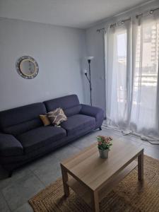 a living room with a blue couch and a coffee table at Mer d'Elen VII in Marseille