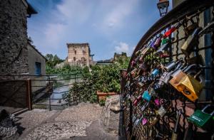 una valla cubierta de cerraduras con un castillo en el fondo en Homelyfeeling, en Castelnuovo del Garda