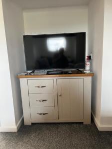 a flat screen tv sitting on top of a cabinet at The Lily Pad in Tavistock