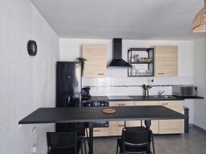a kitchen with a black counter top and a refrigerator at Mer d'Elen VII in Marseille