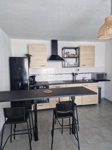 a kitchen with a black counter and some chairs at Mer d'Elen VII in Marseille