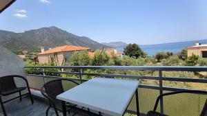 a table and chairs on a balcony with a view of the ocean at Ntaskas apartments in Poulithra