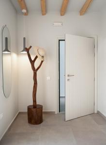 una habitación con una lámpara y un árbol. en Castello Amorgos Suites en Katapola