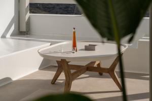 una mesa blanca con una botella y una caja en ella en Castello Amorgos Suites, en Katápola