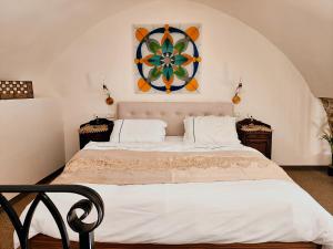 a bedroom with a large bed with a painting on the wall at Templars suite in ‘Akko