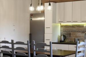 a kitchen with a table and a stainless steel refrigerator at FJAKA - Kuća za odmor - NP Krka in Drniš