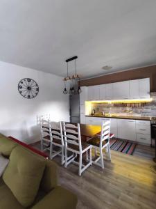 a kitchen with a table and chairs and a clock at FJAKA - Kuća za odmor - NP Krka in Drniš +39 photos