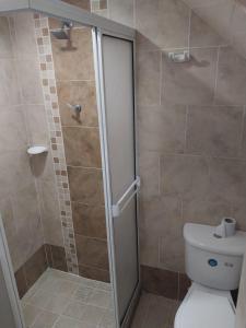 een badkamer met een douche en een toilet bij HOTEL DULCES SUEÑOS in Buenaventura