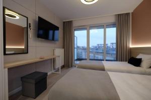 a hotel room with two beds and a television at Apartamenty Centrum in Białystok