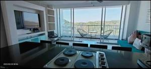 sala de estar con vistas a una cocina con fogones en Dpto con Espectacular Vista al Mar Acapulco Diamante - Condominio TorreBlanca, en Acapulco