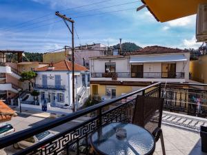 a balcony with a table and some buildings at ThassCities Casa Studios in Limenas