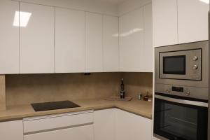 uma cozinha com armários brancos e um micro-ondas em Apartamento La Verita Santiago em Santiago de Compostela