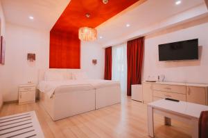 een witte slaapkamer met een bed en een televisie bij Mr.I Boutique Hotel & Bar in Ohrid