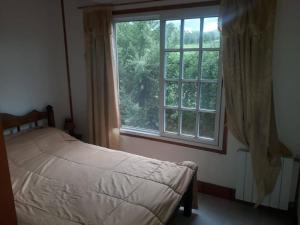 a bedroom with a bed and a large window at Finca Lo de Guarin in Vaqueros