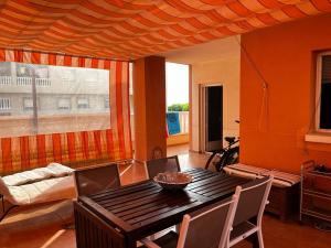 a dining room with a table and a couch at Apartamento La Manga Del Mar Menor in La Manga del Mar Menor