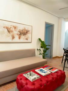 sala de estar con sofá y reposapiés rojo en Apartamento La Manga Del Mar Menor, en La Manga del Mar Menor