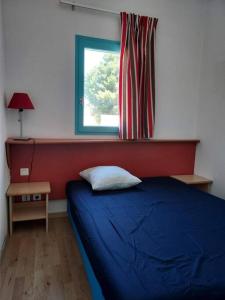 - une chambre avec un lit bleu et une fenêtre dans l'établissement Maisonnette Bleue Caraïbe, à Argelès-sur-Mer