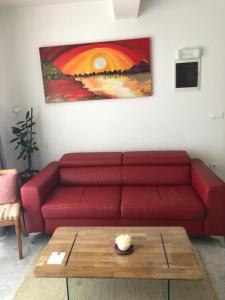 een rode bank in een woonkamer met een salontafel bij Apartment Petrovic Medulin in Medulin