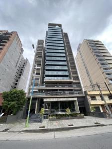 zwei hohe Gebäude vor einer Straße in der Unterkunft Departamento del Parque in San Miguel de Tucumán