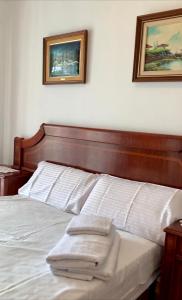een slaapkamer met een bed met twee foto's aan de muur bij Villa Felicidad in Vilanova i la Geltrú