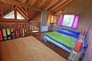 um quarto com 2 camas num chalé de madeira em Cabaña Las Alpinas em Villa La Angostura